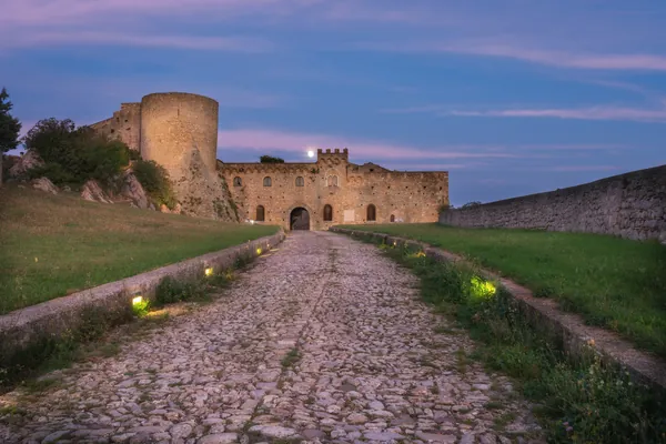 Il castello di Bovino al tramonto, con la strada lastricata
