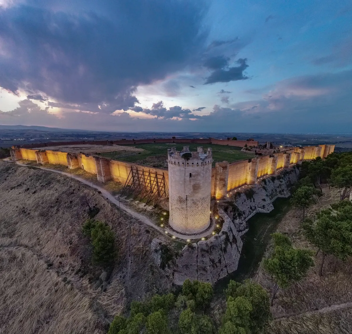 La Fortezza Svevo-Angioina de Lucera vue d'en haut, avec ses remparts illuminés à l'heure bleue